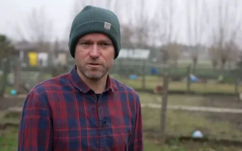 Een jonge man vertelt in zijn tuin