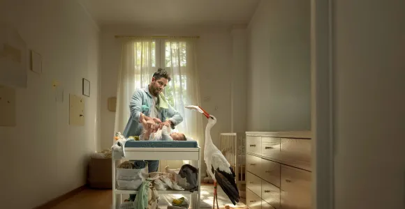 papa verzorgt baby die op de verzorgingstafel ligt