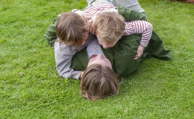 mama die met haar twee kindjes in het gras ligt
