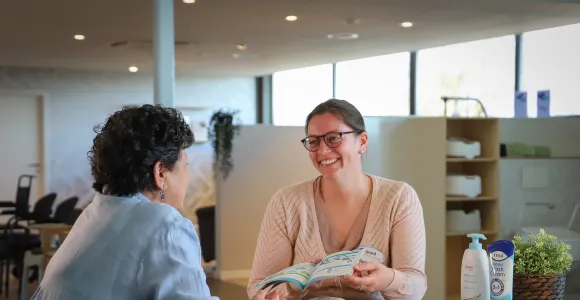 Vrouw geeft uitleg aan klant in de Goed zorgwinkel