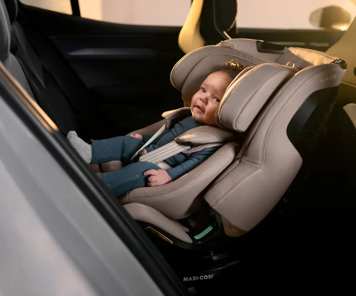 Baby lacht in een autostoel in de wagen.